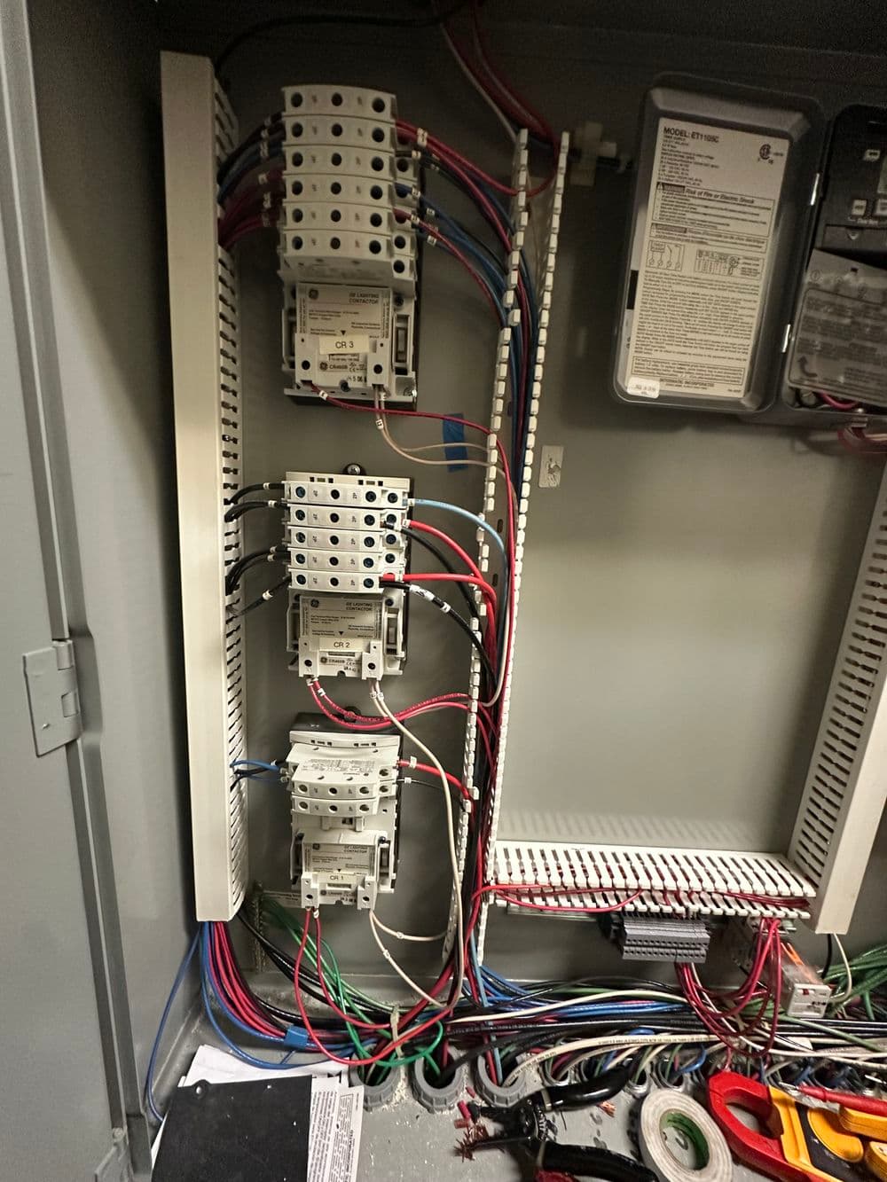 Electrical panel featuring multiple circuit breakers and intricate wiring connections.