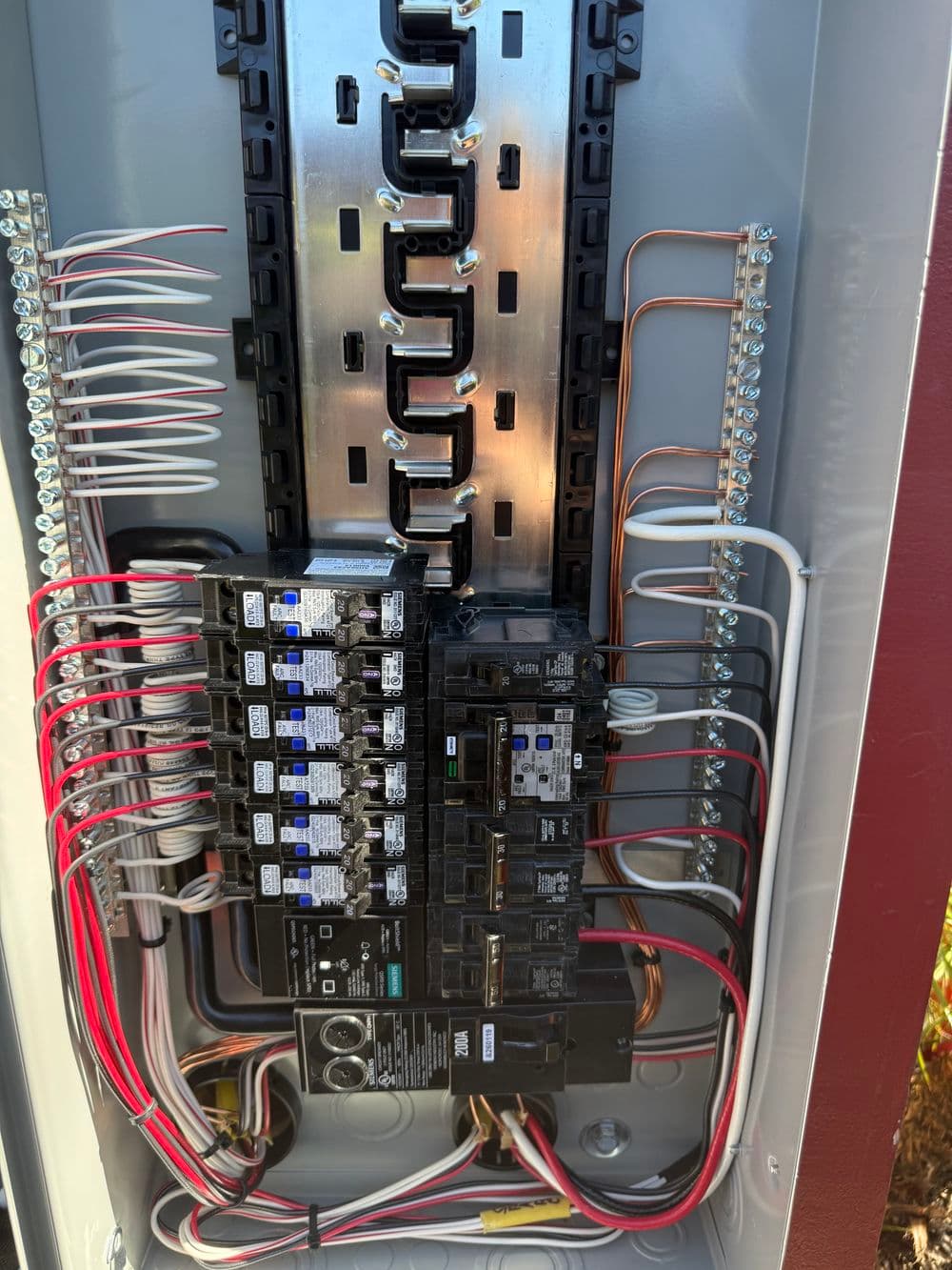 Close-up of a residential electrical panel showing circuit breakers and wiring.