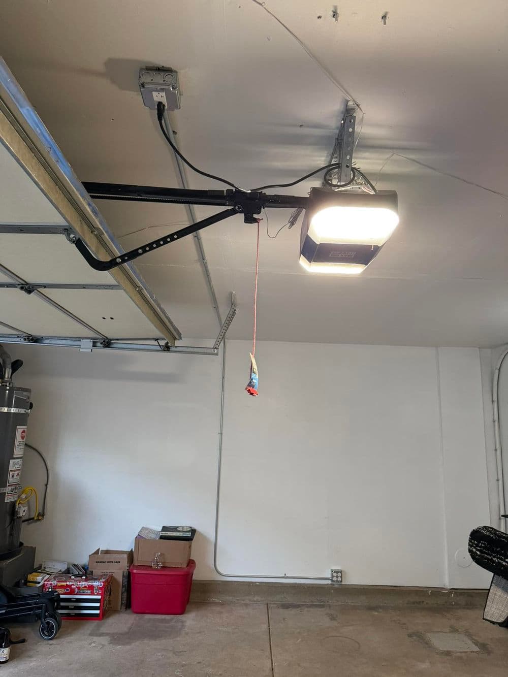 Garage interior featuring an overhead LED light and garage door opener on the ceiling.